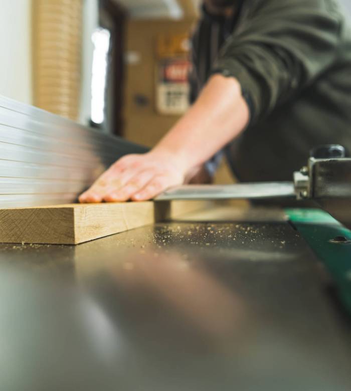 carpenter using a table saw while working in his woodworking studio, extreme closeup shot. High quality photo
